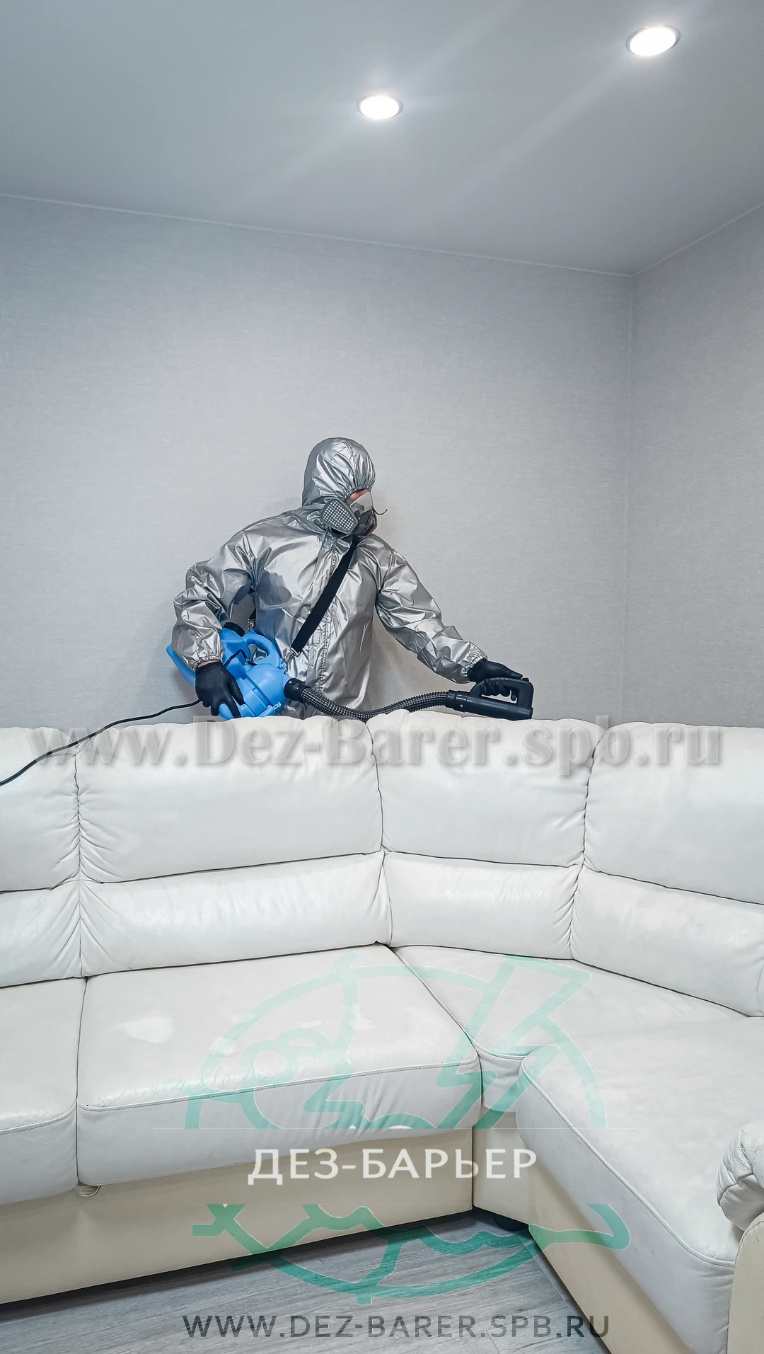 Дезинфектор в защите обрабатывает угловой белый диван